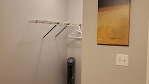 Un pasillo estrecho con un ventilador de techo, un aire acondicionado de pared, un tendedero y un cuadro.