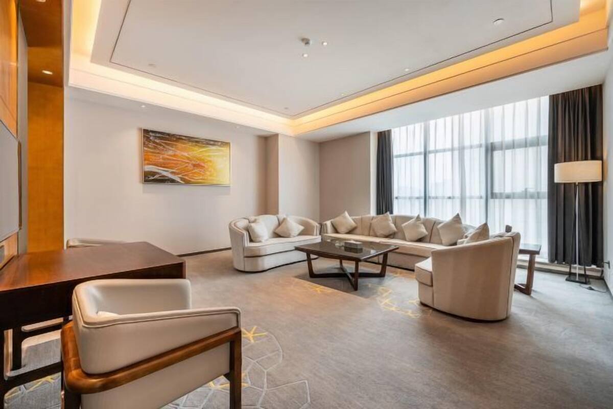 A modern living room with a sofa set, a coffee table, and a dining table.