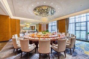 A conference room with a round table, chairs, and a chandelier. - Grand Skylight Hotel (Weinan)