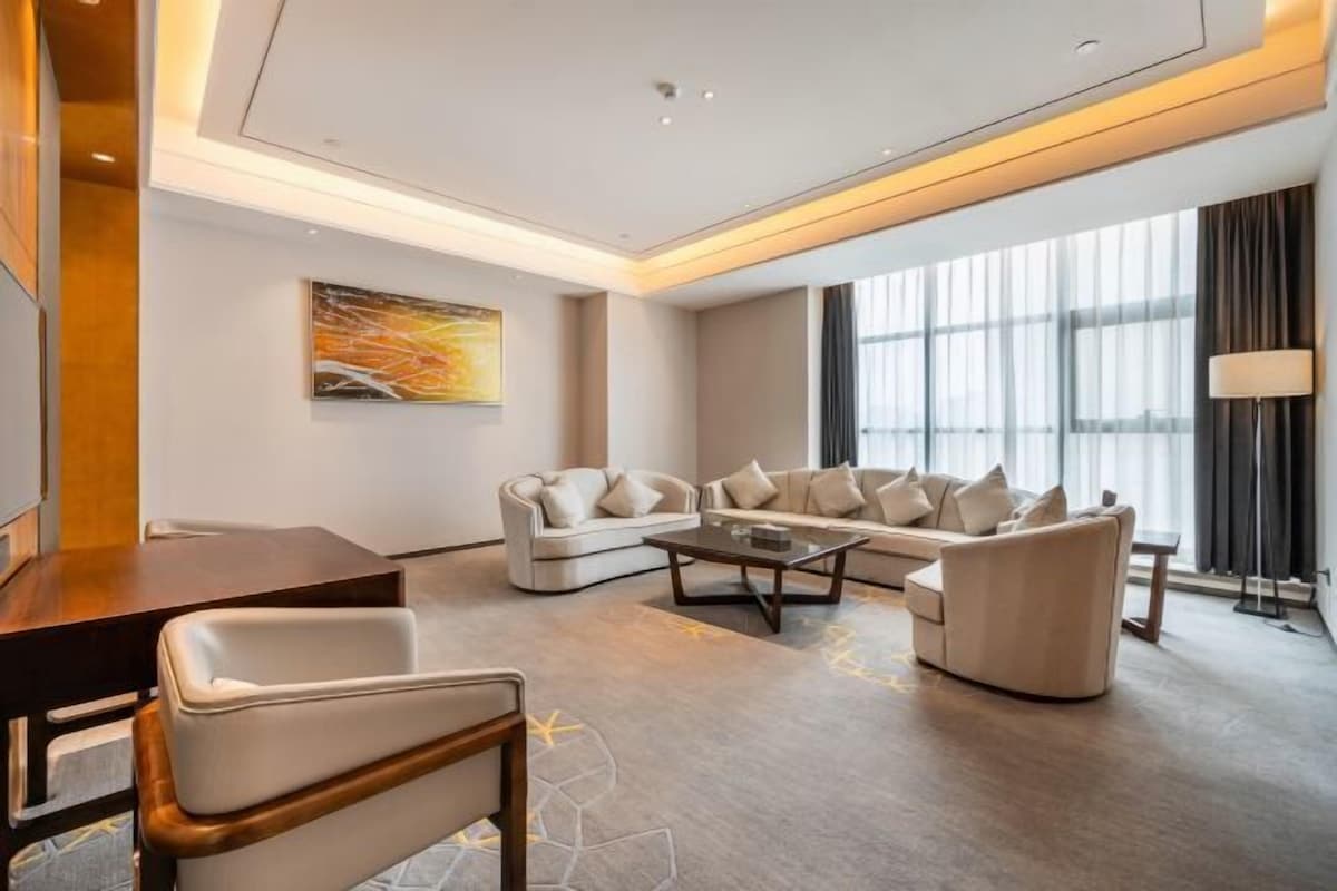 A modern living room with a sofa set, a coffee table, and a lamp.