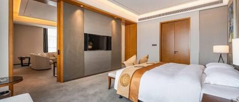 Una habitación de hotel con una cama grande, un escritorio, una silla y un televisor.