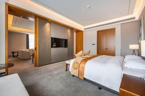 A hotel room with a large bed, a desk, a chair, and a TV. - Grand Skylight Hotel (Weinan)