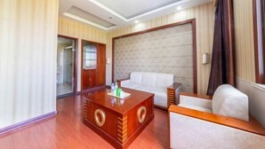Una sala de estar moderna con una mesa de centro de madera, un sofá blanco y un televisor grande montado en la pared.