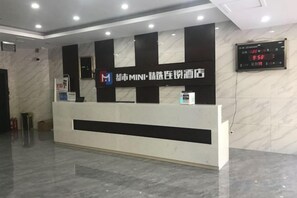 A reception desk with a digital clock displaying the time. - Fuxin Hotel (Xuancheng)