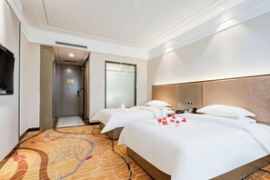 A hotel room with two beds, a flat-screen TV, and a carpeted floor. - Jiuzhou International Hotel (Tongchuan)