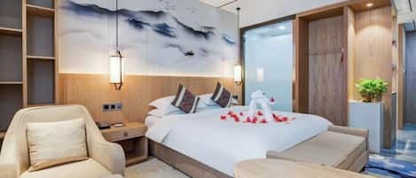 Una habitación de hotel moderna con una cama grande, un área de descanso y un mural en la pared.