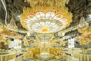 Un salón de banquetes con una decoración floral central, candelabros y asientos escalonados.