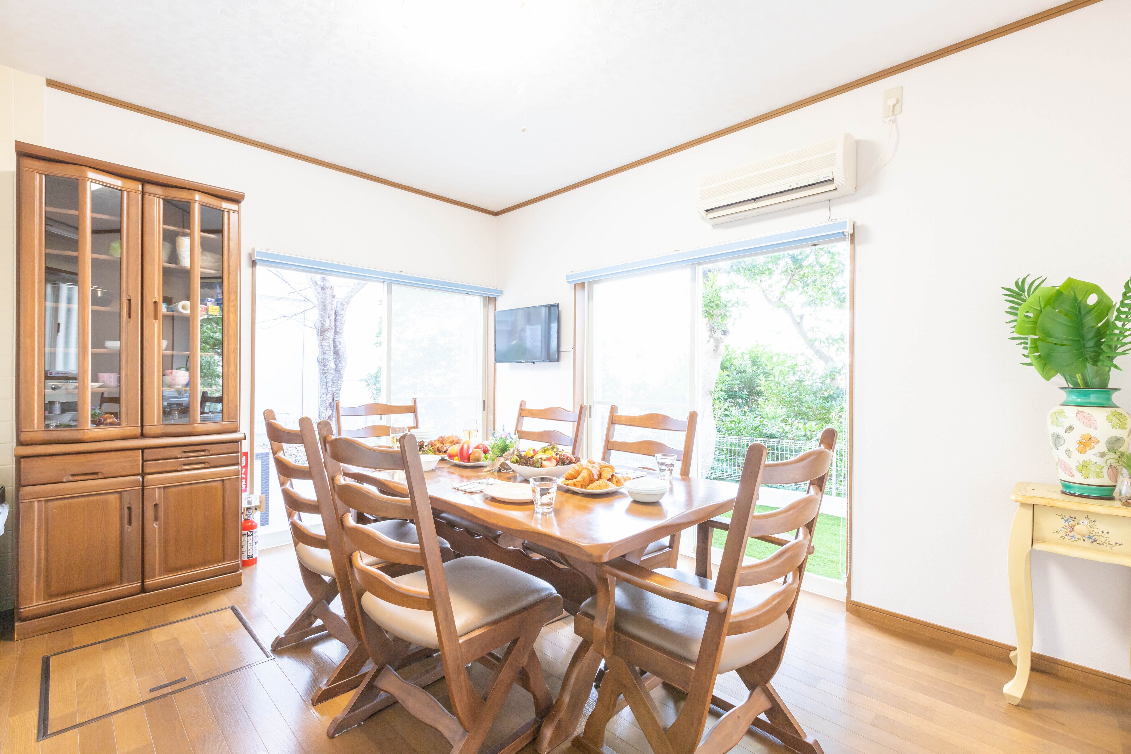 Un comedor con una mesa de madera, sillas y un armario.
