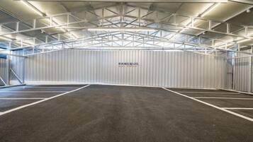 Instalación deportiva interior con techo alto y una pared central que muestra el texto