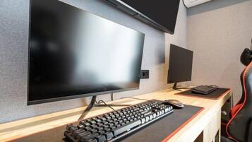 A modern office setup with a large flat-screen monitor, a smaller monitor, a keyboard, and a mouse on a desk.