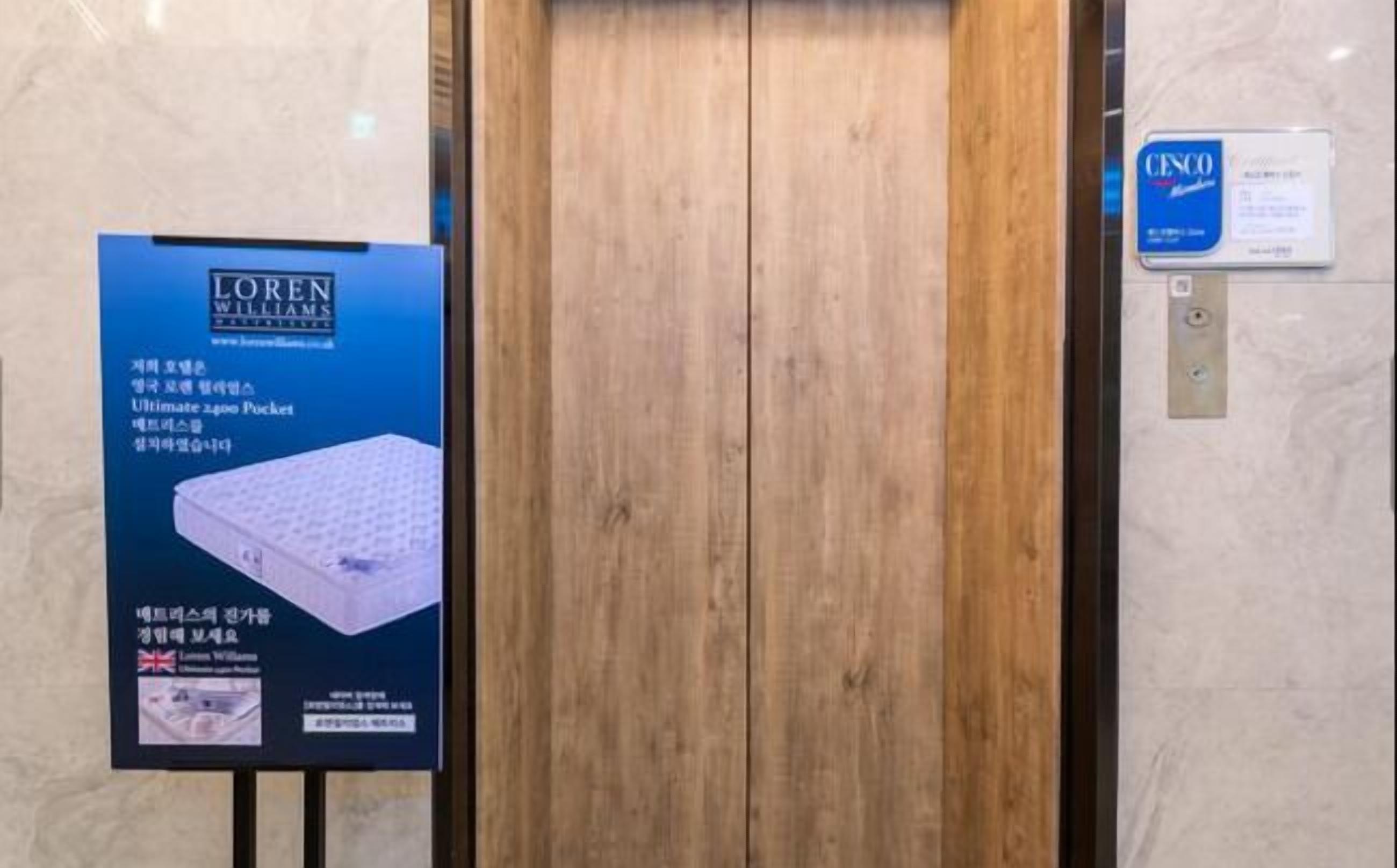 A wooden door with a sign on the left advertising a mattress.
