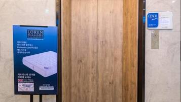 A wooden door with a sign on the left advertising a mattress.