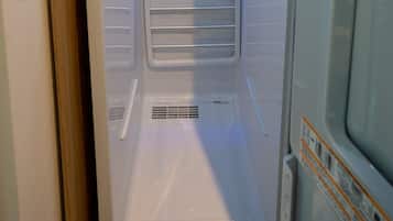 A compact, modern room with a built-in shower, a control panel, and a ventilation system.