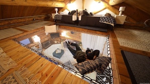 A cozy attic bedroom with a large skylight, a bed, and a seating area.