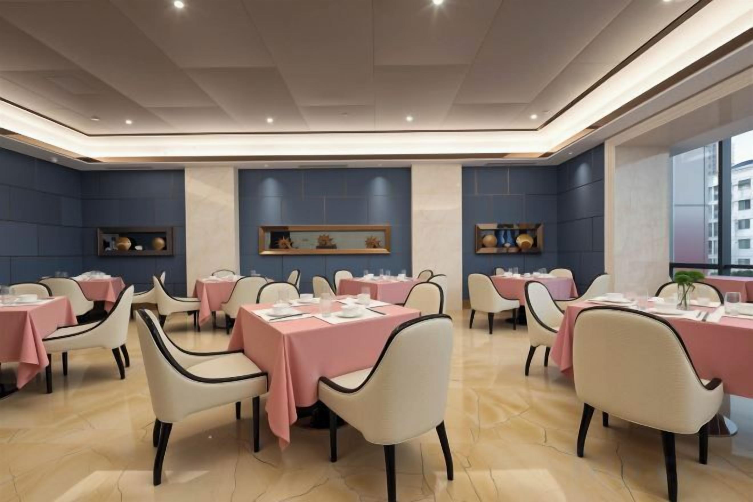 A dining area with tables set for multiple guests, featuring a modern design with a neutral color palette.