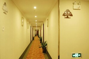 A hotel hallway with a carpeted floor, framed pictures on the walls, and a sign indicating the elevator. - GreenTree Inn (Feng County Liubang Square) (Feng County)