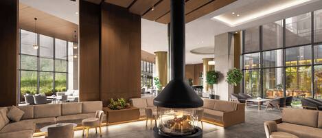 Un área de estar moderna con chimenea central, asientos cómodos y ventanas amplias que ofrecen vistas al exterior.