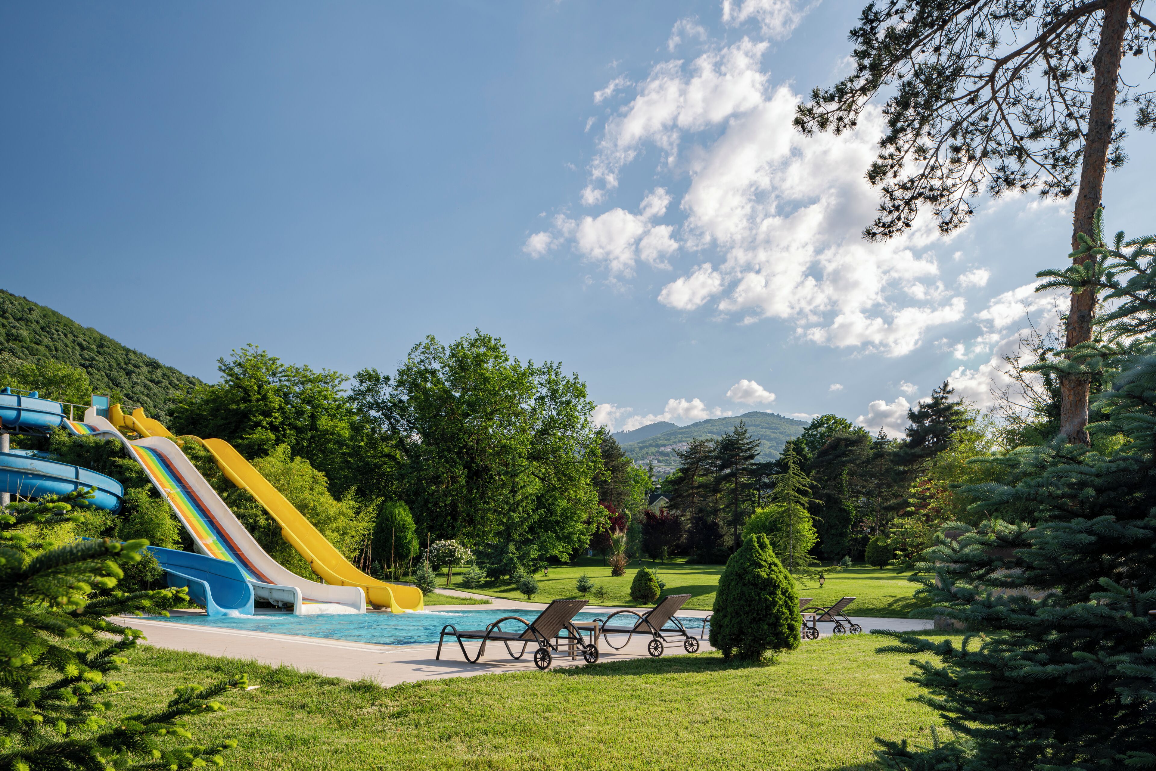 A pool area with slides and lounge chairs.