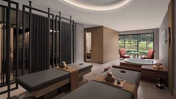 Relax in a serene space with a large window offering a view of the outdoors, a seating area, and a massage table.