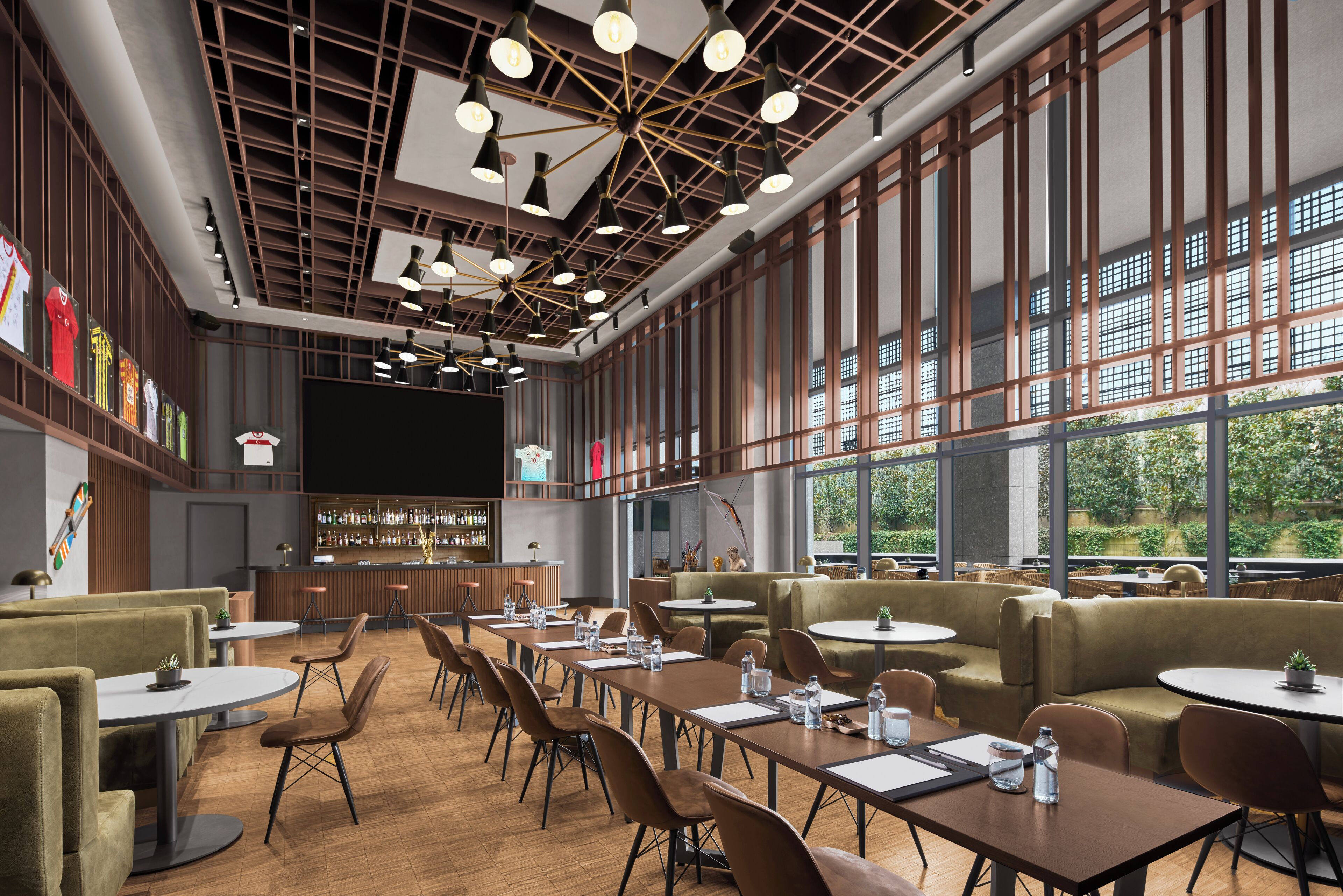 Restaurante moderno com pé-direito alto, vigas aparentes e grandes janelas com vista para áreas verdes. Mesas e cadeiras dispostas para refeições.
