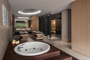 Une salle de bain moderne avec une grande baignoire ovale, un meuble-lavabo en bois et une cabine de douche en verre.