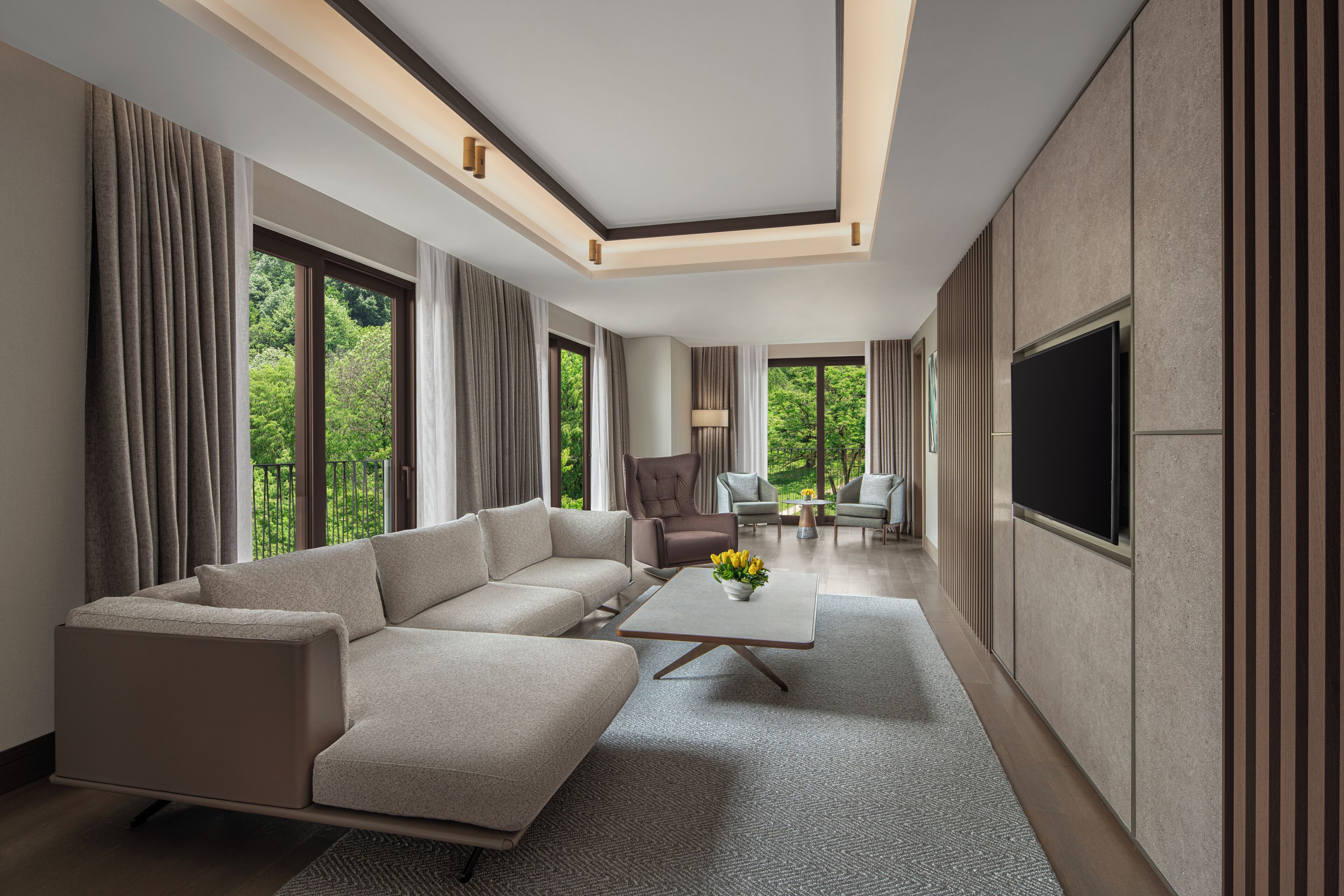 Una sala de estar moderna con un sofá modular, una mesa de centro y un televisor de pantalla plana.