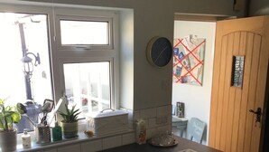 Una cocina con ventana, un reloj y un mapa en la pared.