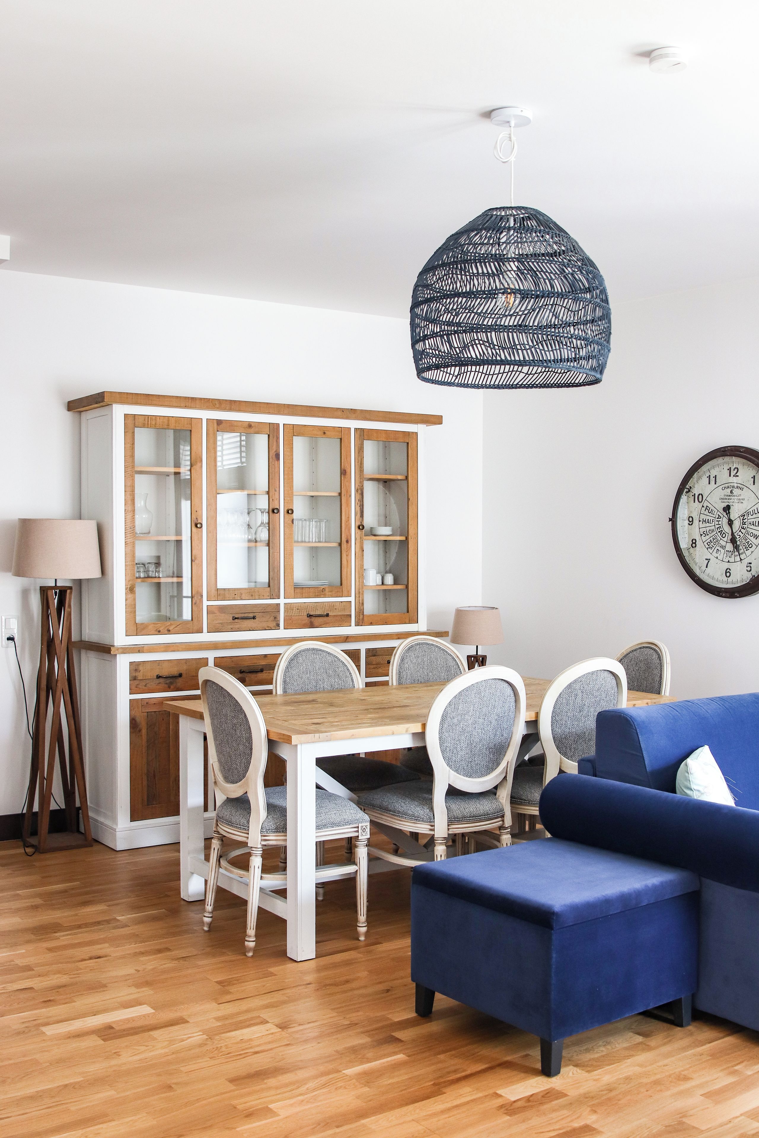 Un comedor con un armario de madera, una mesa redonda y sillas.
