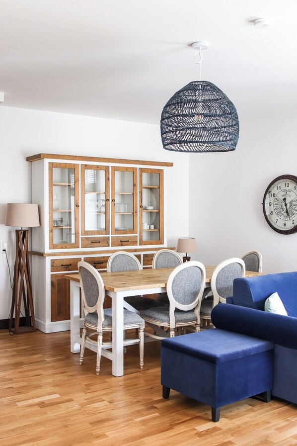 A dining area with a wooden cabinet, a round table, and chairs.