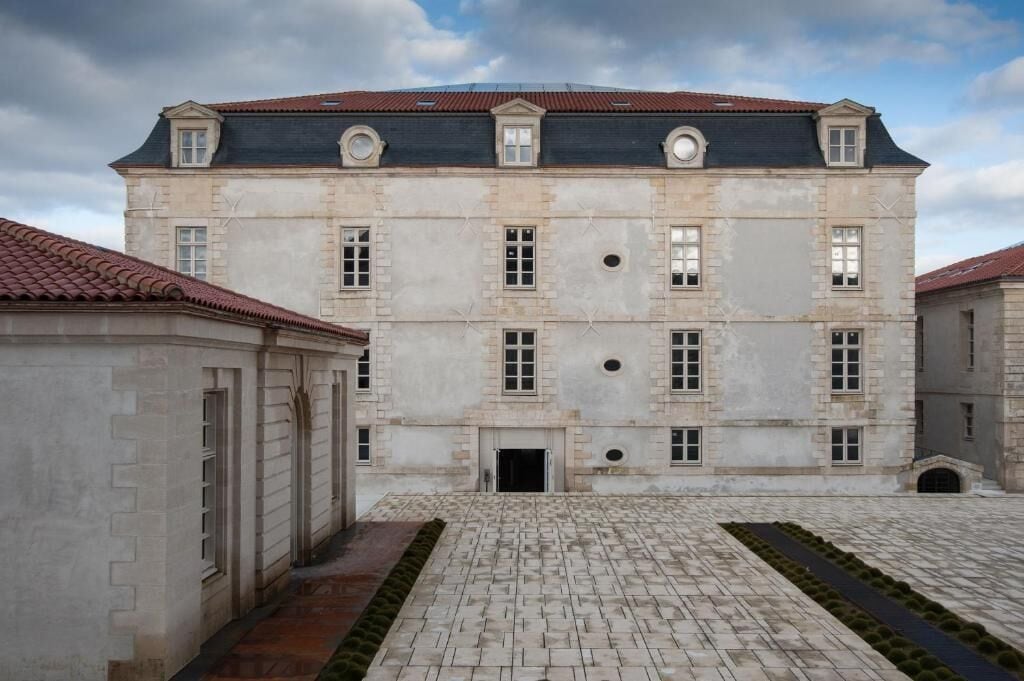 A historic building with a symmetrical facade, large windows, and a central entrance.