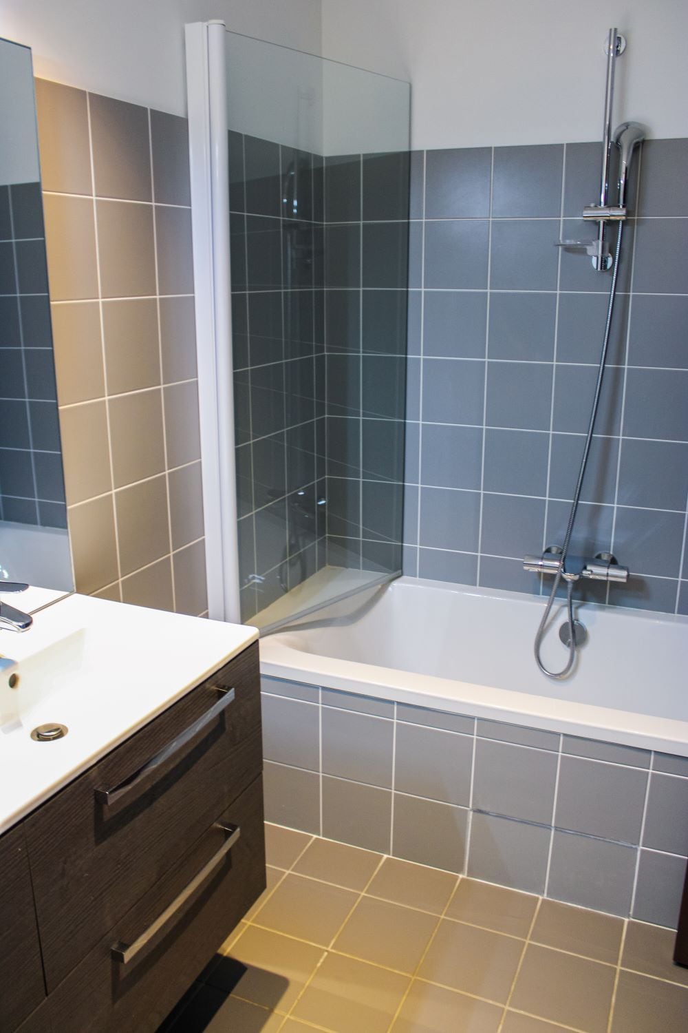 Un baño con bañera, cabina de ducha de vidrio y tocador con espejo.