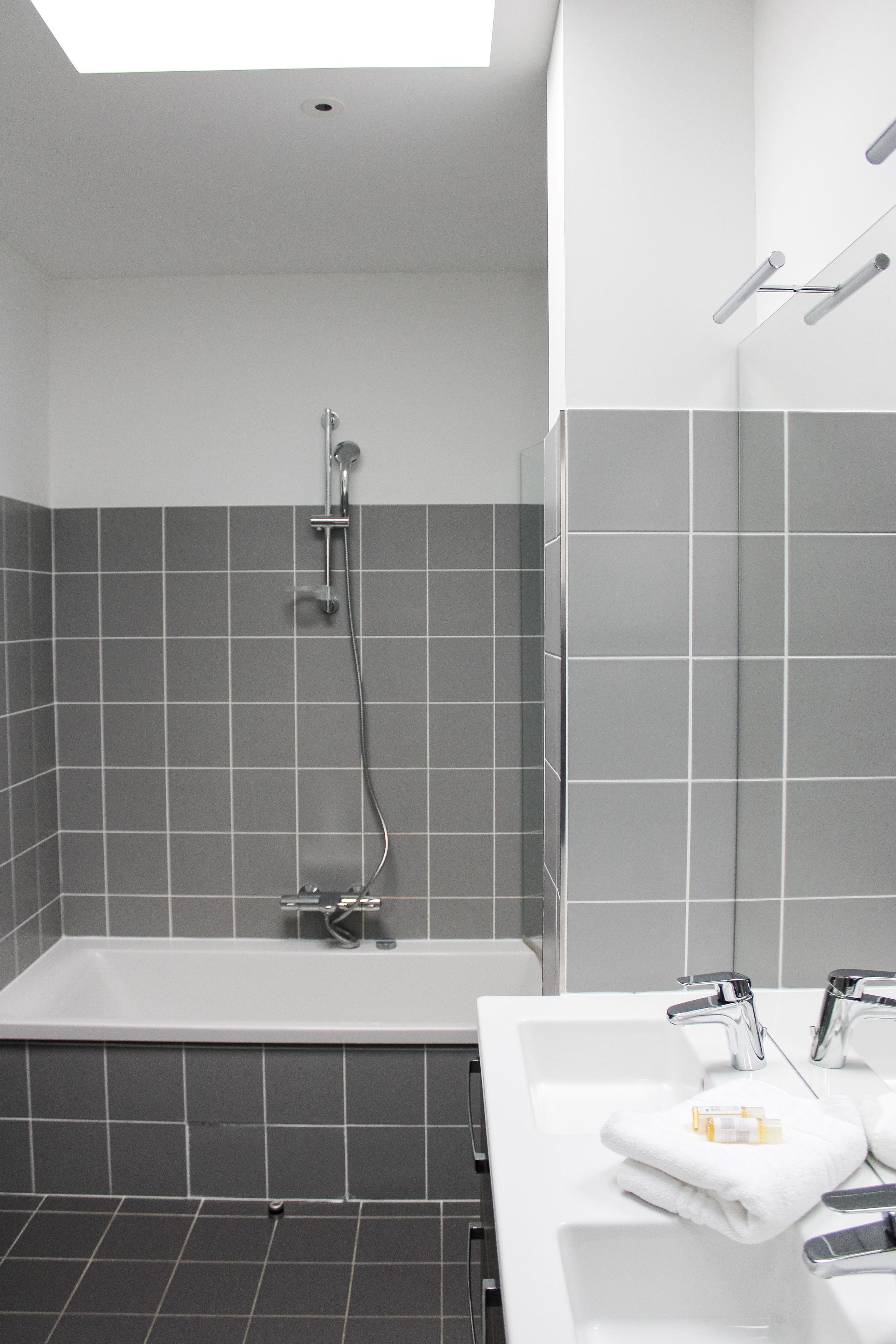 Une salle de bain moderne équipée d’une baignoire, d’une douche et d’un lavabo.