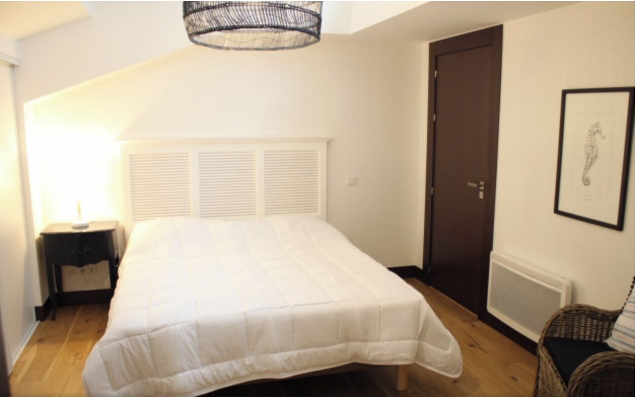 A bedroom with a bed, a nightstand, a door, and a radiator.