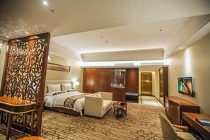 A hotel room with a bed, a sofa, a desk, and a TV. - Hui En International Hotel (Gao'an)