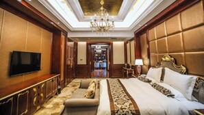 A luxurious hotel room with a large bed, a sofa, a TV, and a chandelier. - Hui En International Hotel (Gao'an)