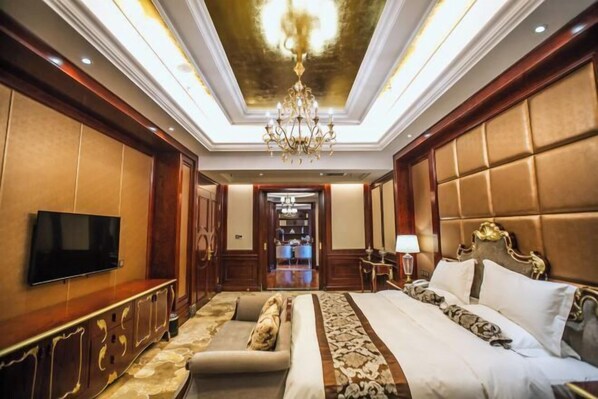 A luxurious hotel room with a large bed, a sofa, a TV, and a chandelier. - Hui En International Hotel (Gao'an)