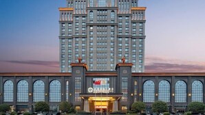 A large, multi-story hotel with a prominent entrance and arched windows. - Hui En International Hotel (Gao'an)