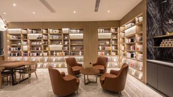 A library with bookshelves, seating, and a marble floor.