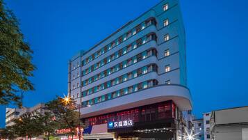 A multi-story hotel with a modern design, featuring a prominent curved facade and multiple windows.