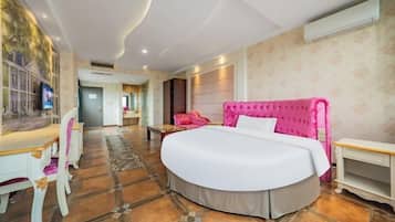 A spacious bedroom with a large bed, a desk, and a chair.