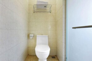 A small, clean bathroom with a white toilet, a towel rack, and a wall-mounted toilet paper dispenser. - Hotel Schönbrunn Palace (Chongqing)