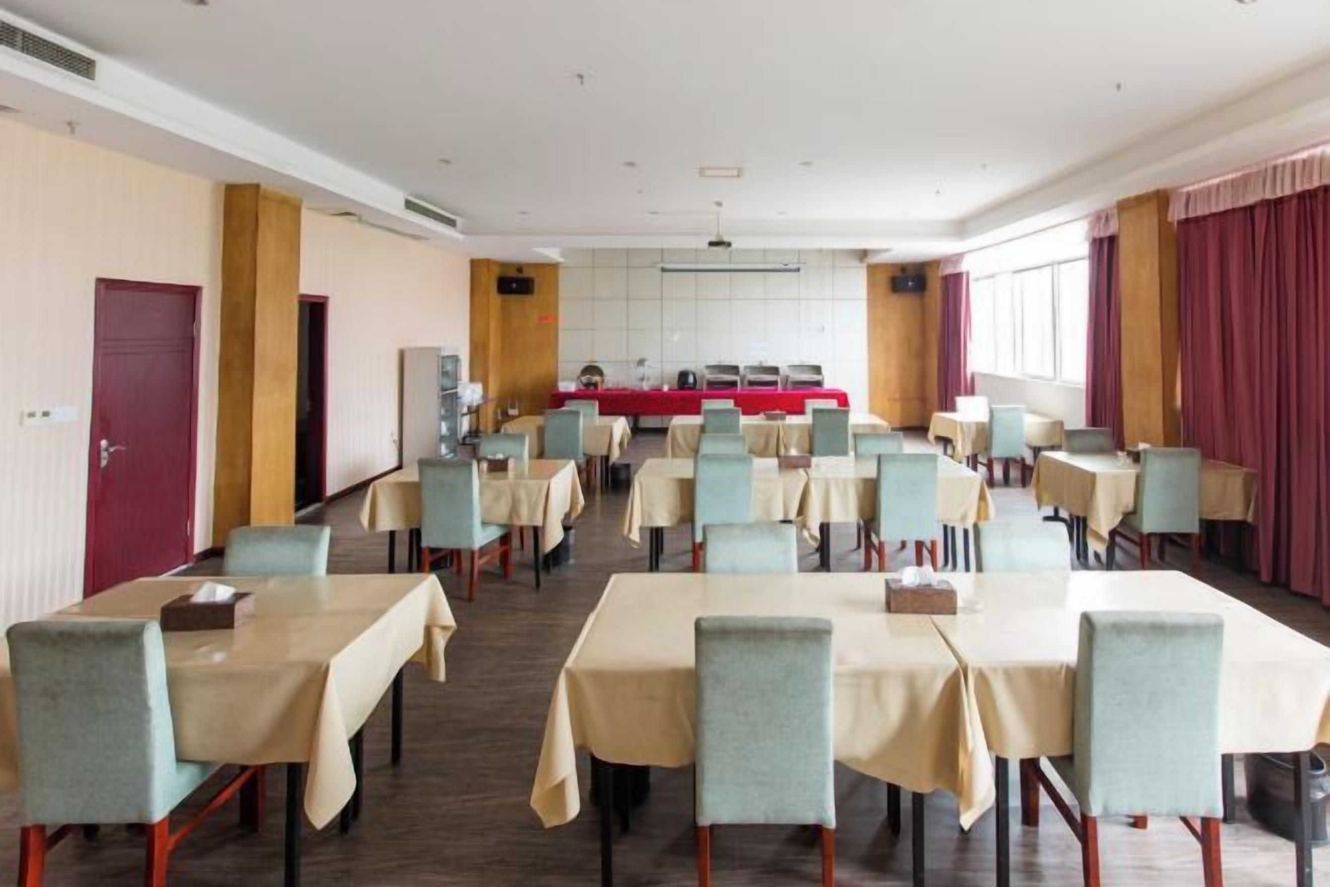 Un salón de conferencias con mesas y sillas dispuestas para una reunión.