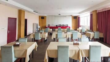 Un salón de conferencias con mesas y sillas dispuestas para una reunión.