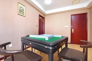 Una habitación con mesa de billar, dos sillas y dos puertas.