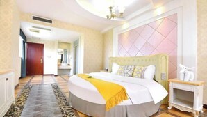 A hotel room with a large bed, a bedside table, a decorative wall panel, and a hallway leading to another room. - Hotel Schönbrunn Palace (Chongqing)