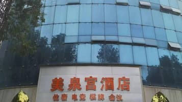 A hotel sign with the name '美泉宫酒店' and contact number '+1583878888'.