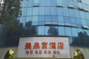 Une enseigne d'hôtel portant le nom « 美泉宫酒店 » et le numéro de téléphone « +1583878888 ».