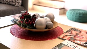 A living room with a wooden coffee table, a bowl of decorative ornaments, and a magazine. - La Pituca Apartment (Playa Blanca)
