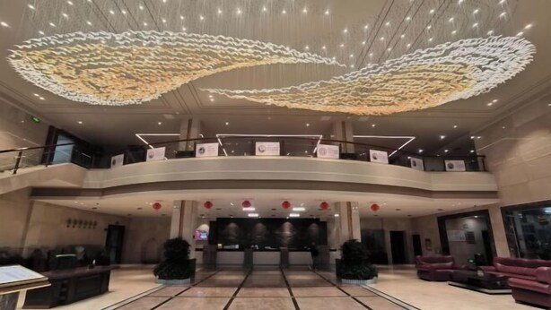 A spacious lobby with a high ceiling, a central reception desk, and multiple seating areas. - JAUNTYO INTERNATIONAL HOTEL (Dayu)