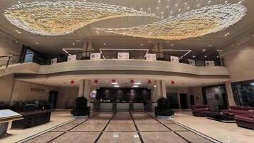 A spacious lobby with a curved ceiling, multiple levels, and a central reception area.